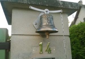 on acheteer une cloche en bronze installe au portail d'une maison